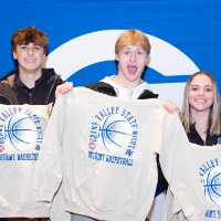 group of 5 people hold up their sweatshirt